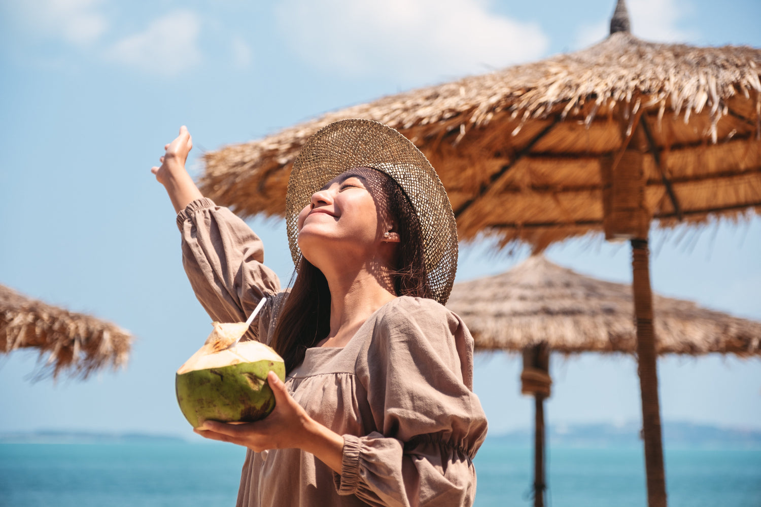 Frau am Strand mit Coconut-Water